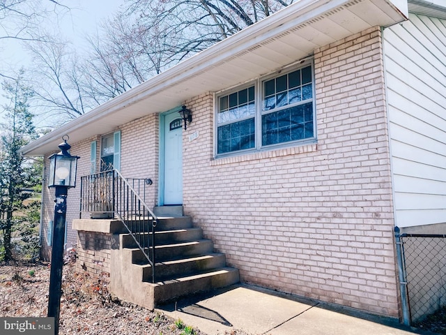 doorway to property with brick siding