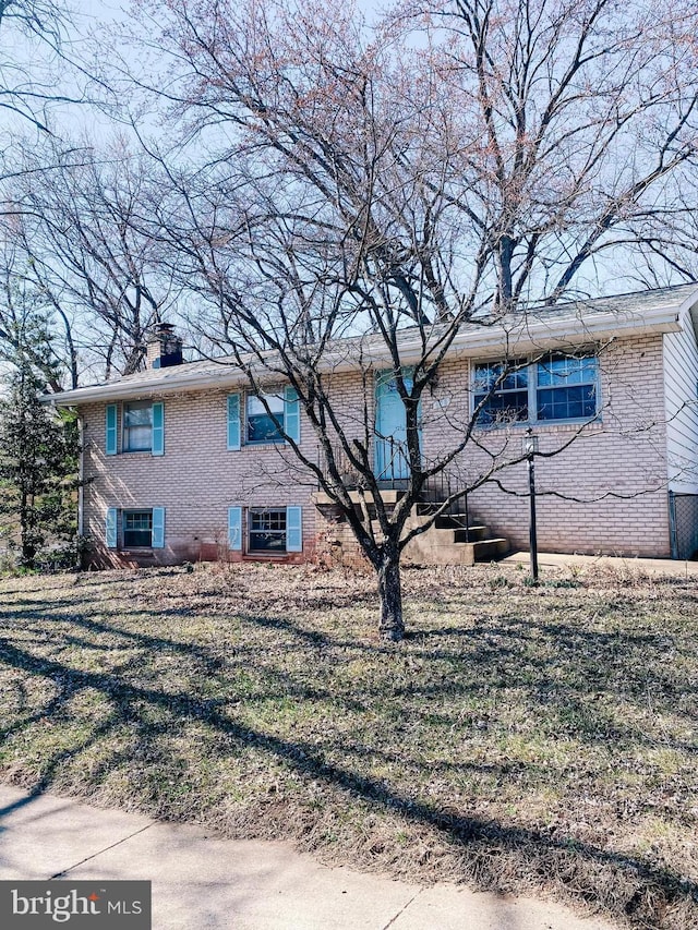 view of side of property featuring brick siding and a chimney