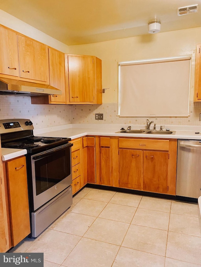 kitchen featuring visible vents, stainless steel appliances, light countertops, under cabinet range hood, and a sink