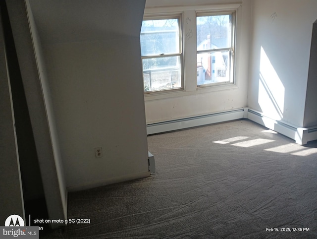 carpeted spare room featuring baseboard heating