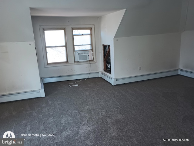 additional living space featuring dark colored carpet, cooling unit, vaulted ceiling, and a baseboard radiator