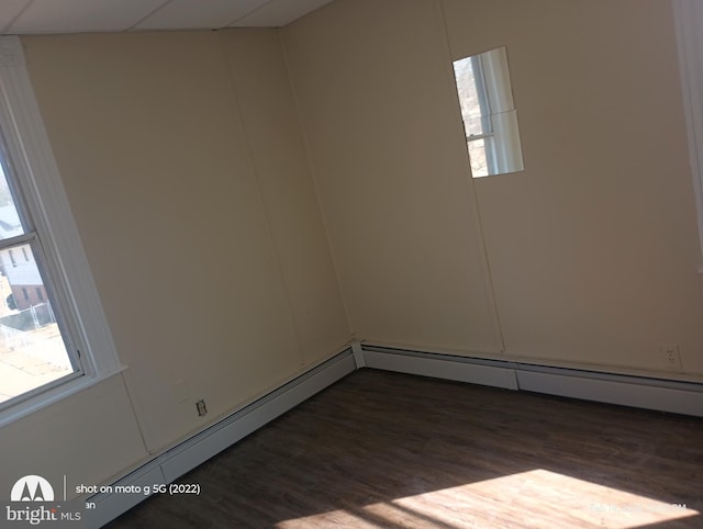 spare room featuring a drop ceiling and dark wood-style flooring