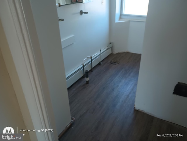 laundry area featuring a baseboard radiator and wood finished floors