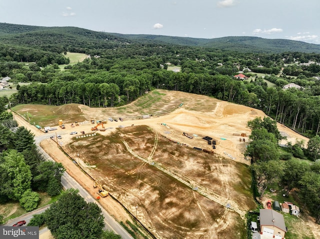 drone / aerial view featuring a mountain view and a wooded view