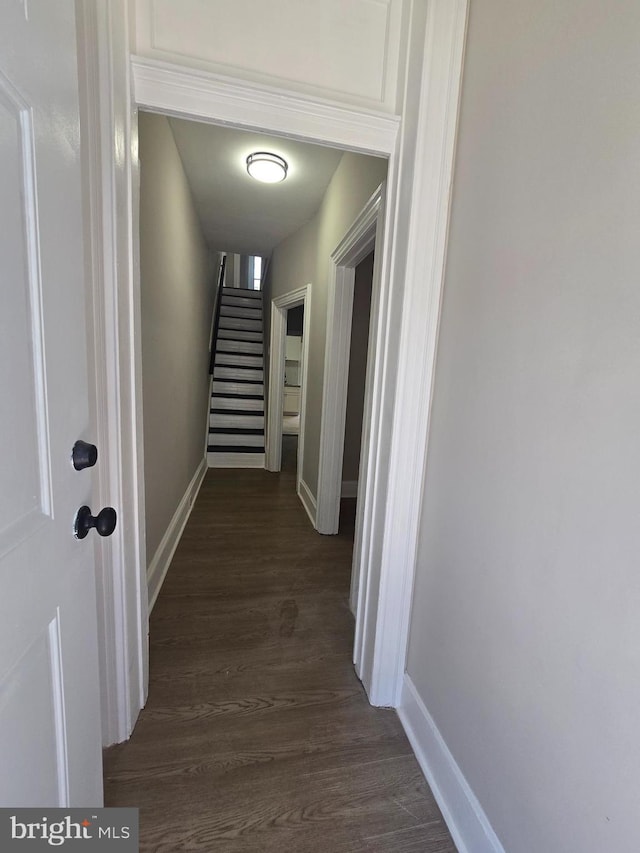 corridor featuring stairway, dark wood finished floors, and baseboards