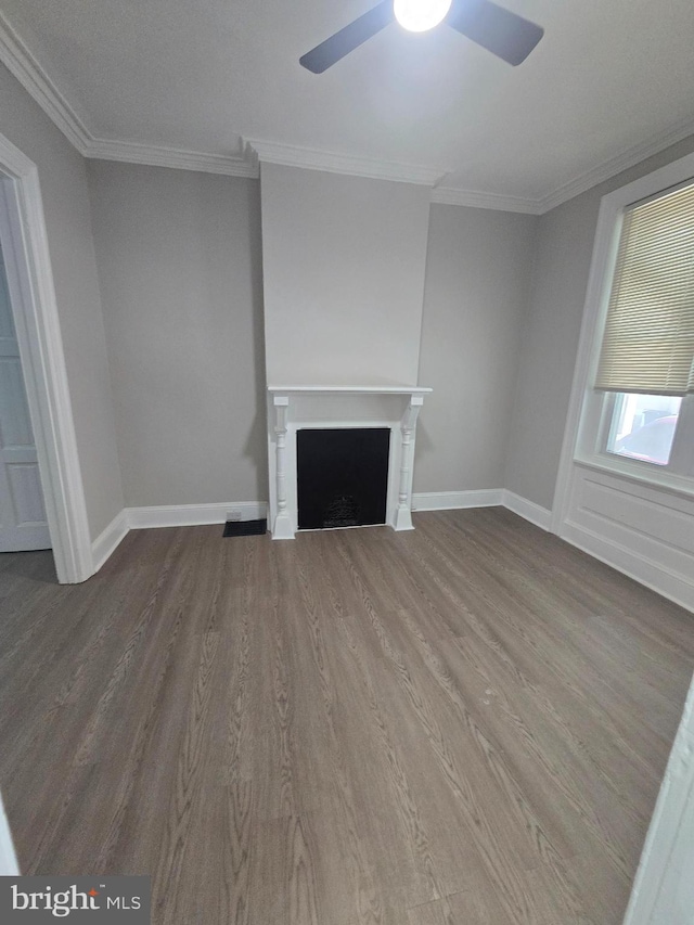 unfurnished living room featuring baseboards, a fireplace, wood finished floors, and crown molding