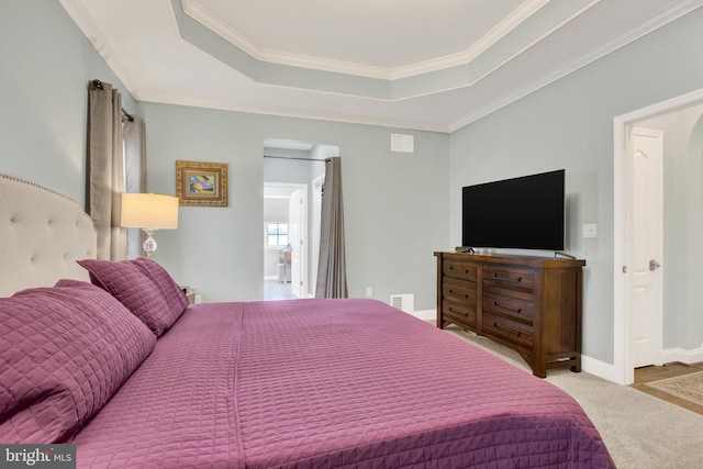 carpeted bedroom featuring ornamental molding, a raised ceiling, visible vents, and baseboards