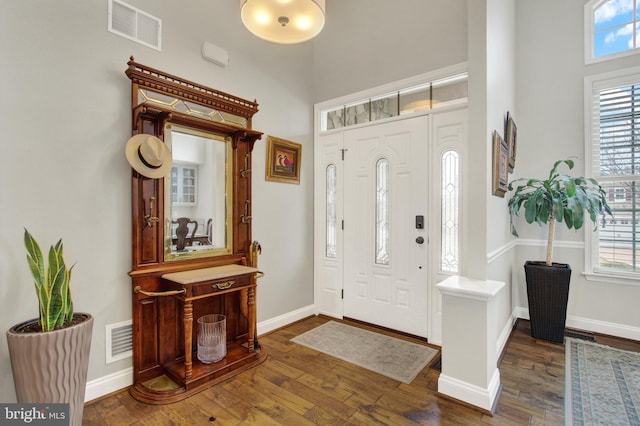 foyer with dark wood-style flooring, visible vents, and plenty of natural light