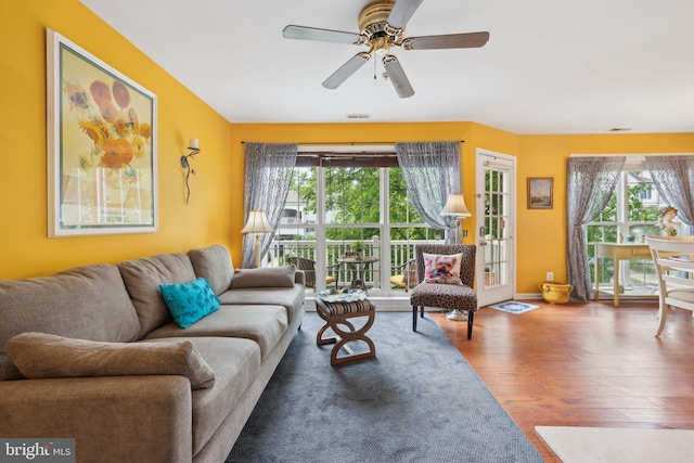 living room with wood finished floors, plenty of natural light, and a ceiling fan