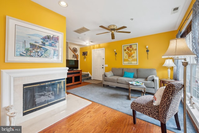 living area featuring wood finished floors, a ceiling fan, a premium fireplace, and recessed lighting