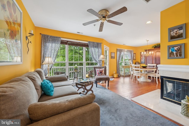 living area featuring ceiling fan, a chandelier, wood finished floors, and recessed lighting