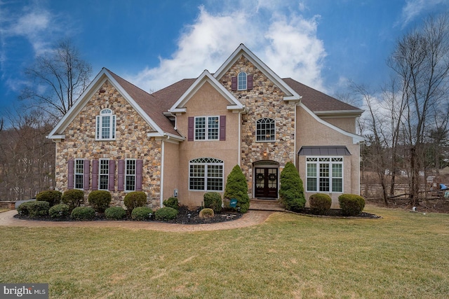 traditional home featuring stone siding, french doors, and a front lawn