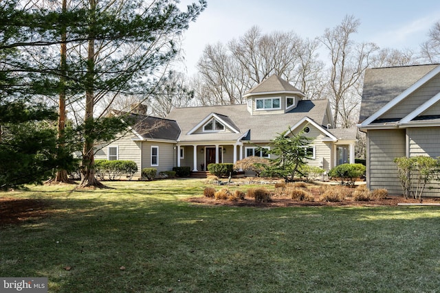 view of front of home featuring a front yard and roof with shingles