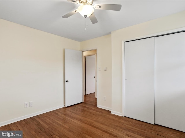 unfurnished bedroom with a ceiling fan, a closet, baseboards, and wood finished floors