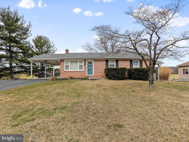 view of front of home featuring a carport, a front yard, driveway, and a chimney