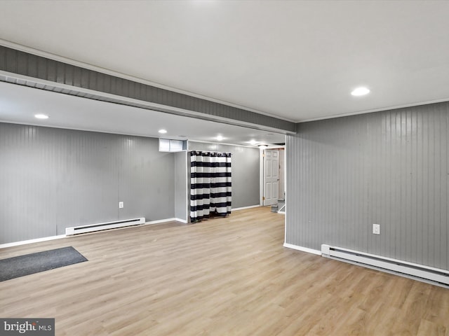 finished basement with light wood-style floors, baseboards, and baseboard heating