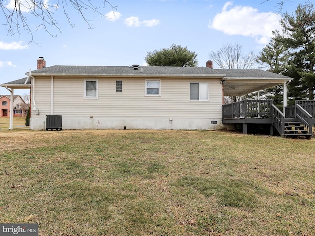 back of house featuring a lawn, a chimney, cooling unit, and a wooden deck