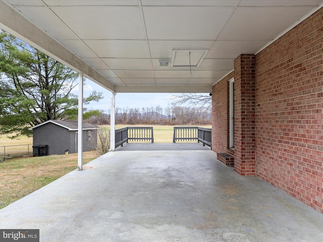 view of patio / terrace with an outbuilding and fence