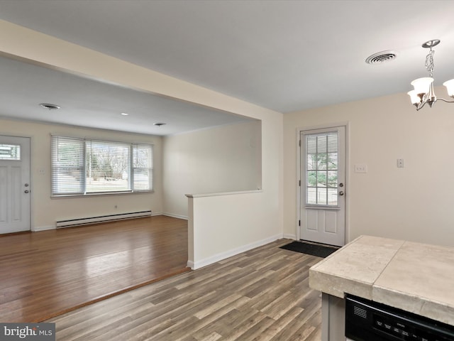 entryway featuring a baseboard radiator, visible vents, an inviting chandelier, wood finished floors, and baseboards