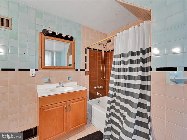 full bathroom featuring shower / tub combo with curtain, tile walls, vanity, and speckled floor