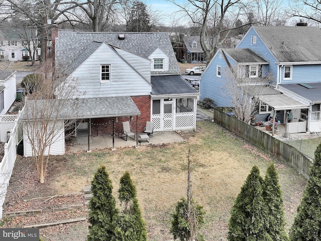 back of property with a sunroom, a fenced backyard, a patio, and brick siding