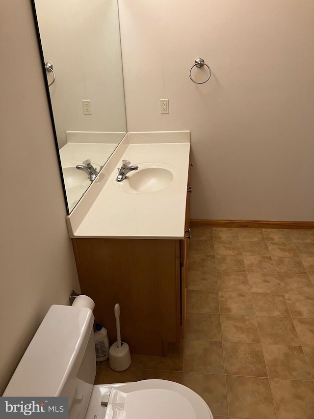 bathroom featuring tile patterned flooring, toilet, vanity, and baseboards