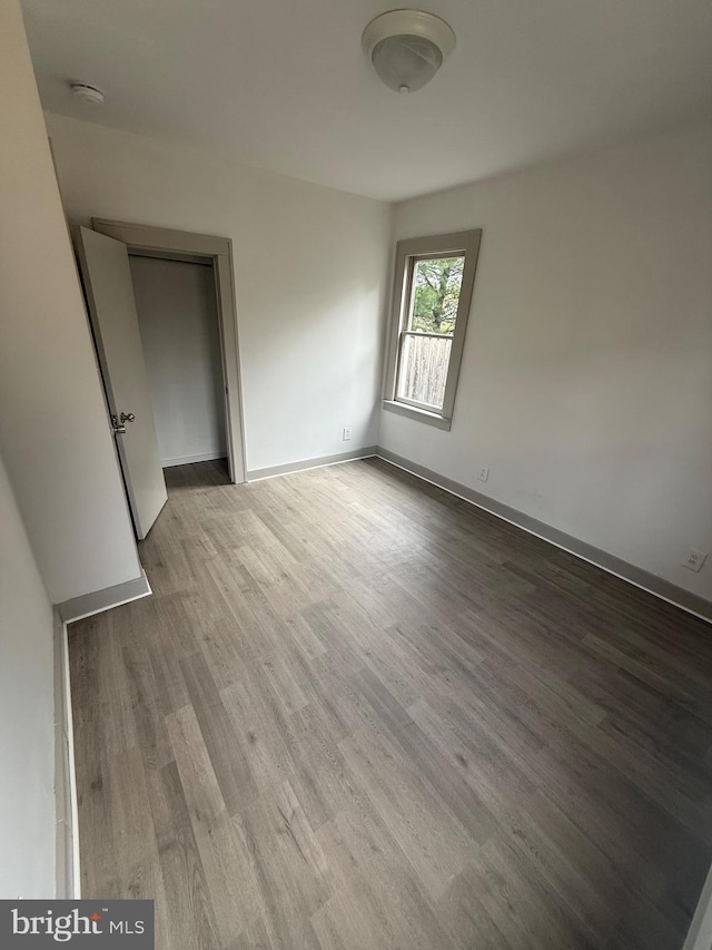 unfurnished bedroom with wood finished floors and baseboards