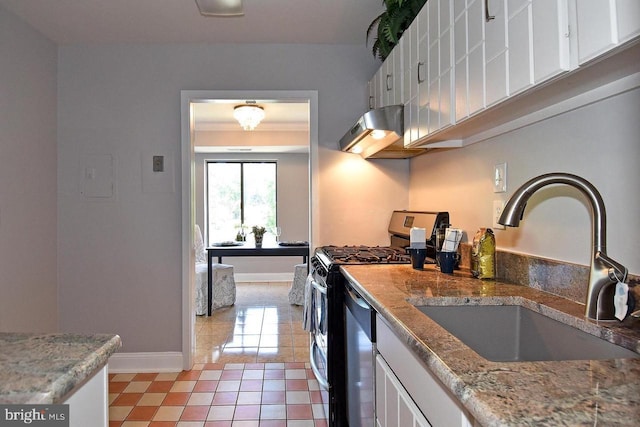 kitchen with baseboards, under cabinet range hood, appliances with stainless steel finishes, white cabinetry, and a sink