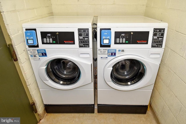 laundry room featuring washer and dryer and concrete block wall