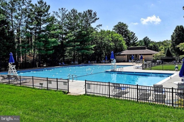 community pool with a patio, a yard, and fence