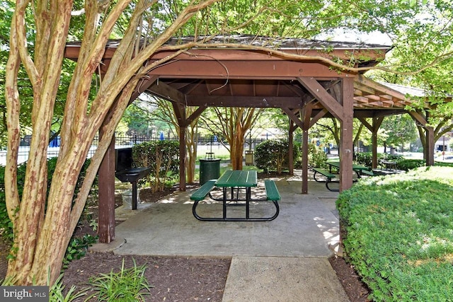 view of community with a gazebo, fence, and a patio area