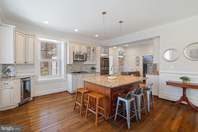 kitchen featuring dark wood-type flooring, a kitchen breakfast bar, wine cooler, and appliances with stainless steel finishes