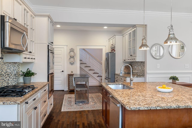 kitchen with ornamental molding, a sink, dark wood-style floors, stainless steel appliances, and glass insert cabinets