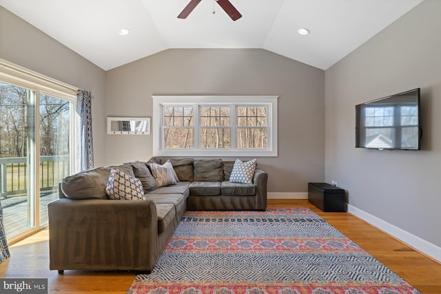 living room with baseboards, wood finished floors, a ceiling fan, and vaulted ceiling