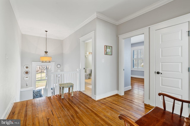 unfurnished dining area with ornamental molding, baseboards, and wood finished floors