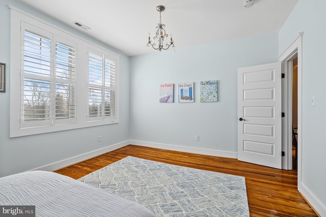 bedroom featuring wood finished floors, visible vents, and baseboards