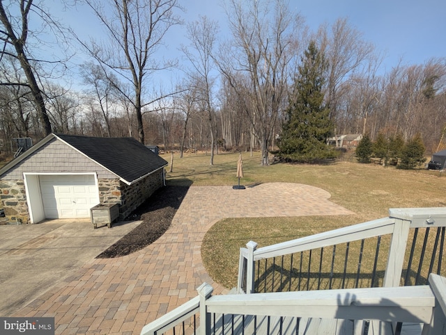 view of patio with a garage, an outdoor structure, and driveway