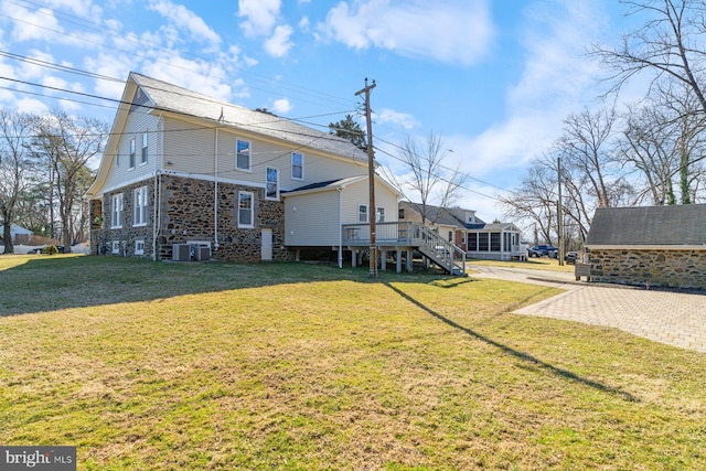 exterior space with stairway, a lawn, and central AC unit