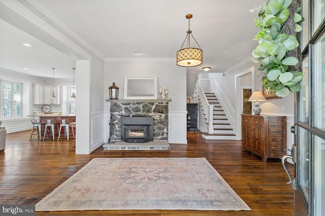 living room with stairs, crown molding, dark wood-style flooring, and wainscoting