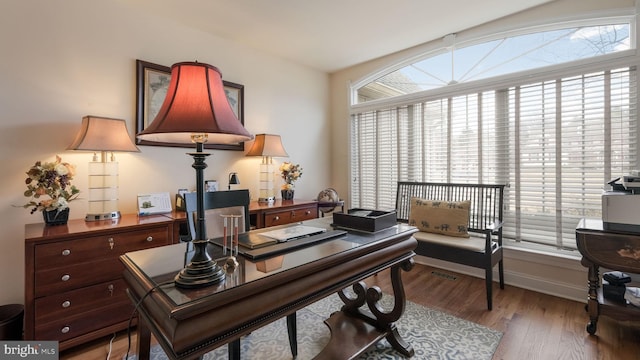 home office with light wood-type flooring and baseboards