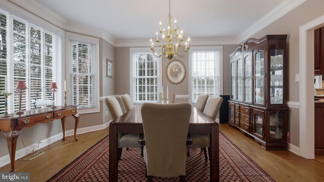 dining space featuring ornamental molding, light wood-style flooring, and an inviting chandelier