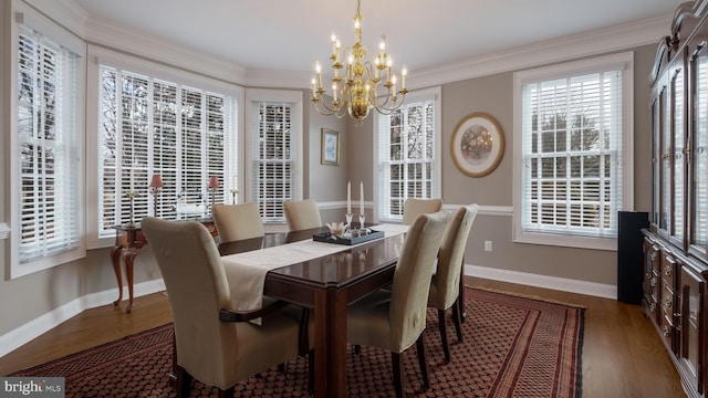 dining room featuring baseboards, a chandelier, wood finished floors, and ornamental molding