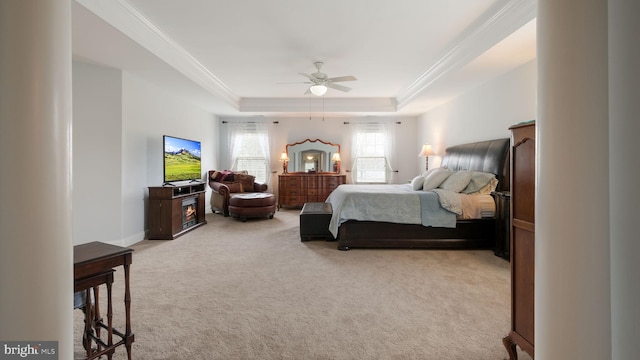 bedroom with carpet floors, a raised ceiling, ornamental molding, ceiling fan, and baseboards