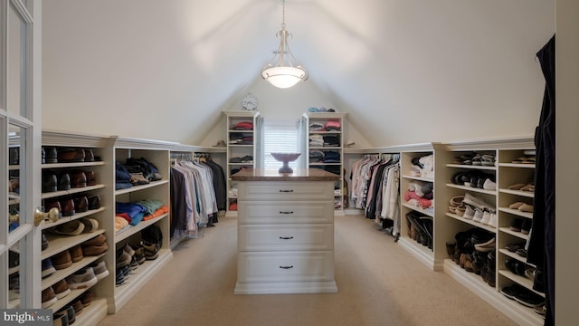 spacious closet with lofted ceiling and light carpet