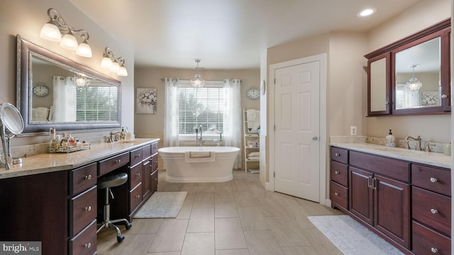 full bathroom with recessed lighting, a soaking tub, and vanity