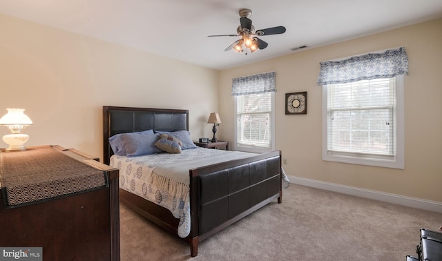 bedroom featuring a ceiling fan, light colored carpet, visible vents, and baseboards