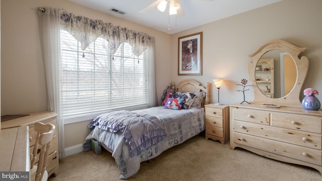 bedroom with light carpet, ceiling fan, visible vents, and baseboards