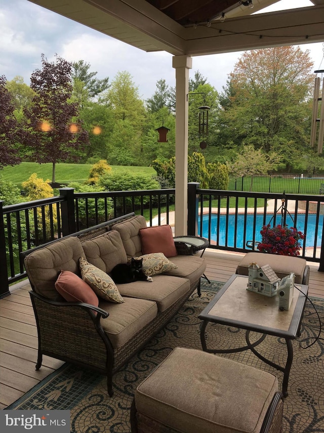 deck with an outdoor hangout area, fence, and a fenced in pool