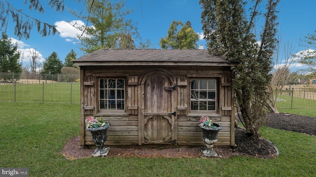 view of outbuilding featuring fence and an outbuilding