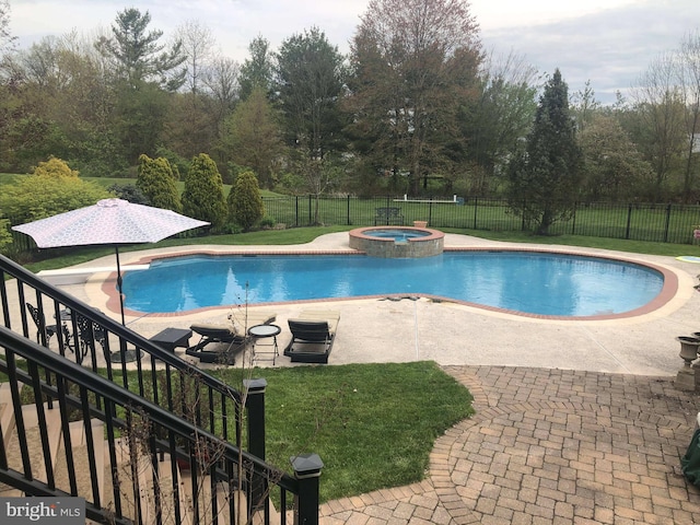 view of pool featuring a pool with connected hot tub, a patio area, fence, and a lawn